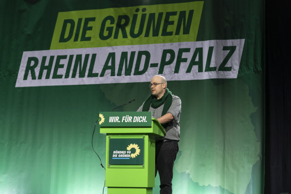 Thomas Hildner am Rednerpult. Im Hintergrund steht: Die Grünen Rheinland-Pfalz